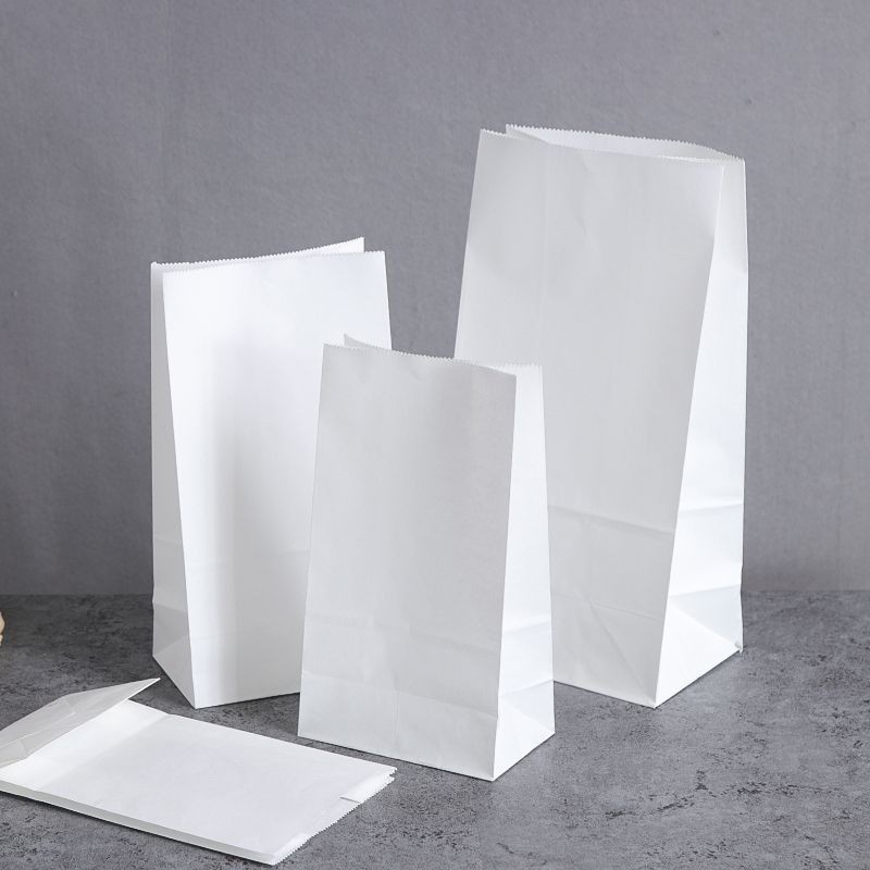 Several white paper bags without handles in small, medium, and large sizes, made from eco-friendly materials for versatile packaging needs